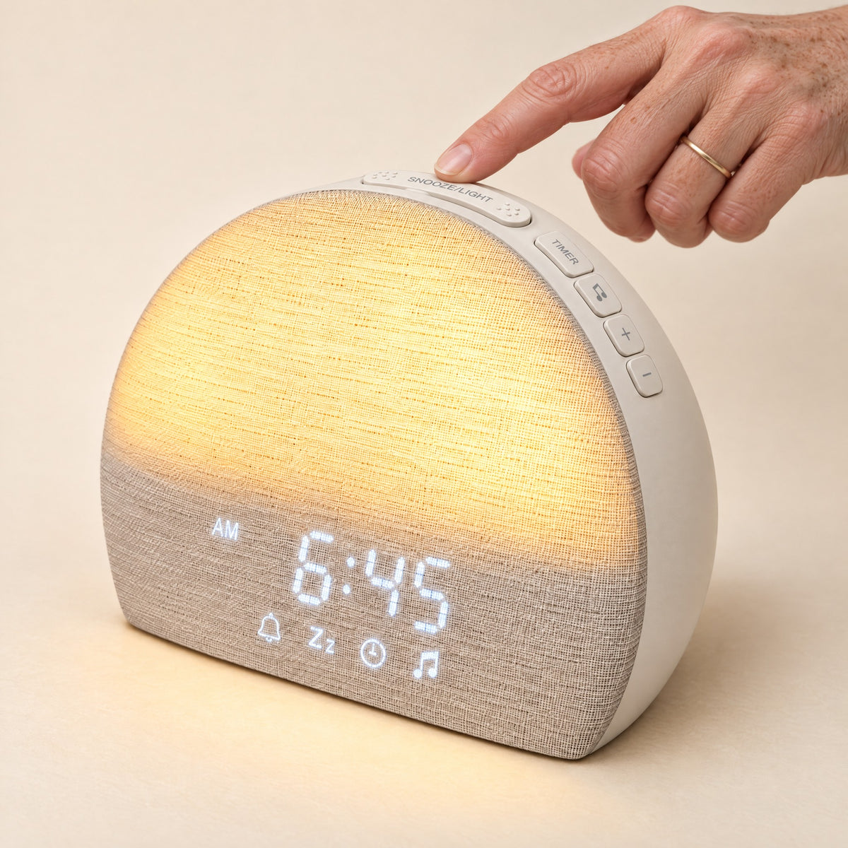 A finger on the long snooze bar across the top of the Sunrise Clock